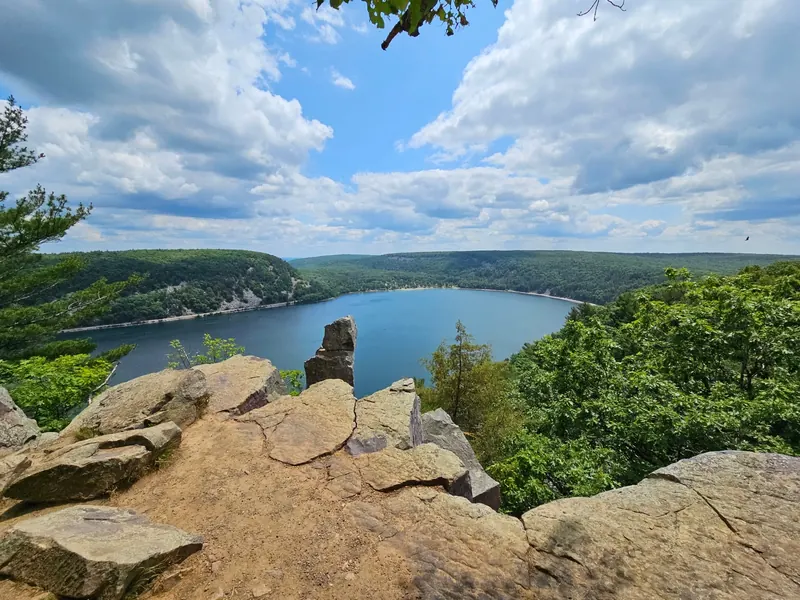 Devil's Lake surrounded by wooded bluffs, viewed from a rocky overlook in the state park