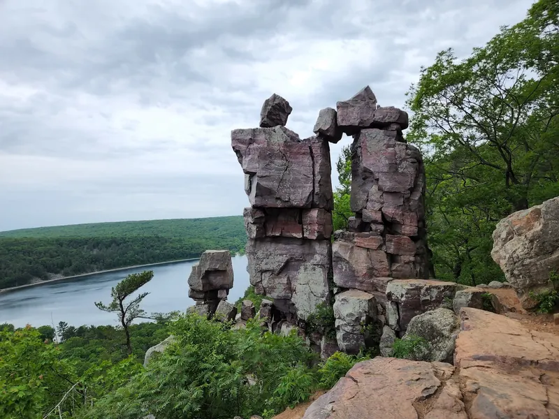 Tall rock columns framing an opening above Devil's Lake and its wooded shoreline